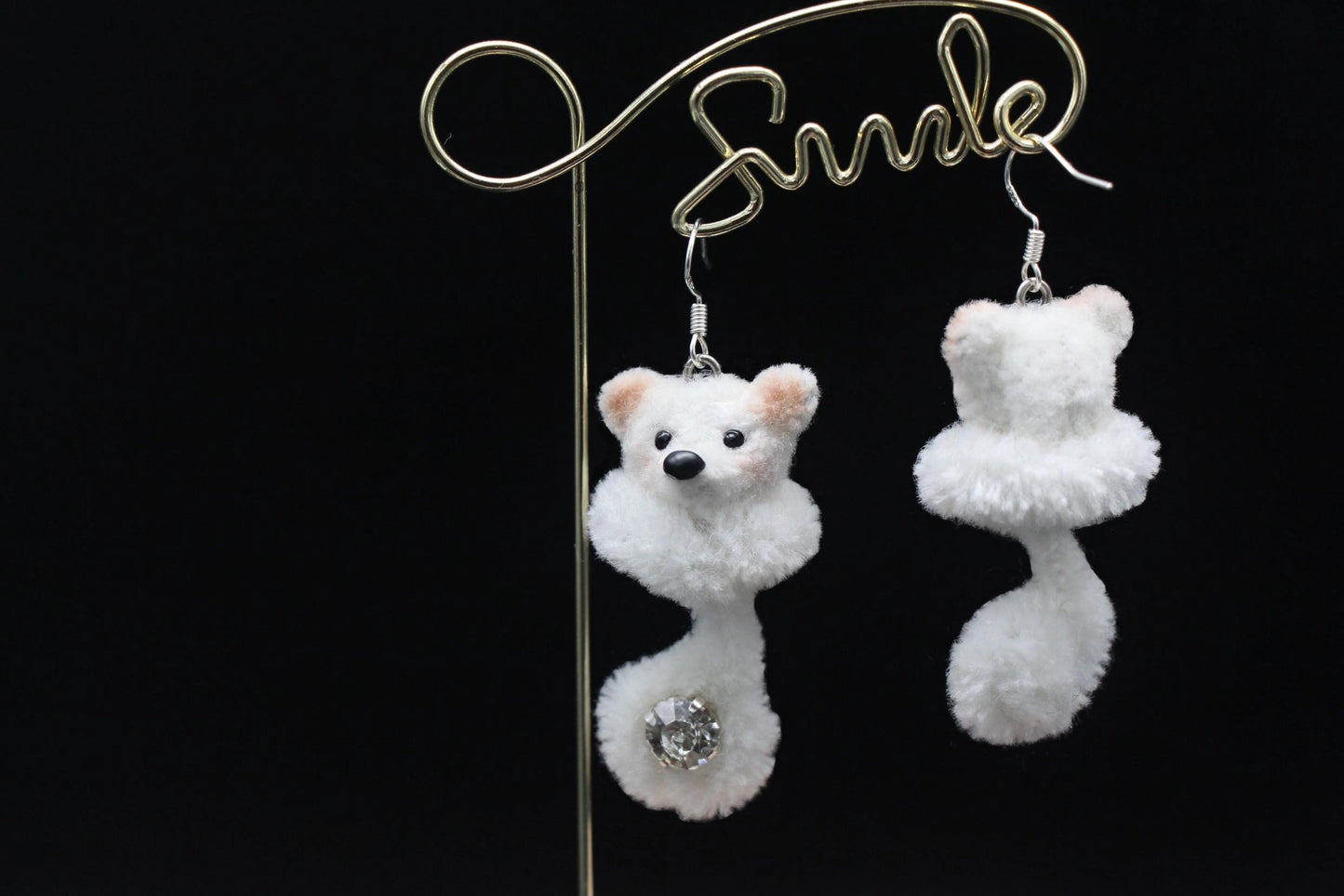 Handcrafted white wool twisted stick puppy earrings with light brown ears, subtle blush, and a sparkling gem on the curled tail, showing front and back details.