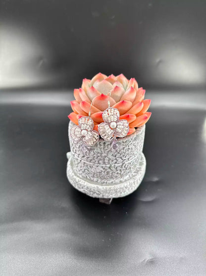 Handcrafted Violet Petal Cascade Camellia beaded dangle earrings with white glass beads, purple woven edges, and a sparkling crystal drop. A pair in the picture.