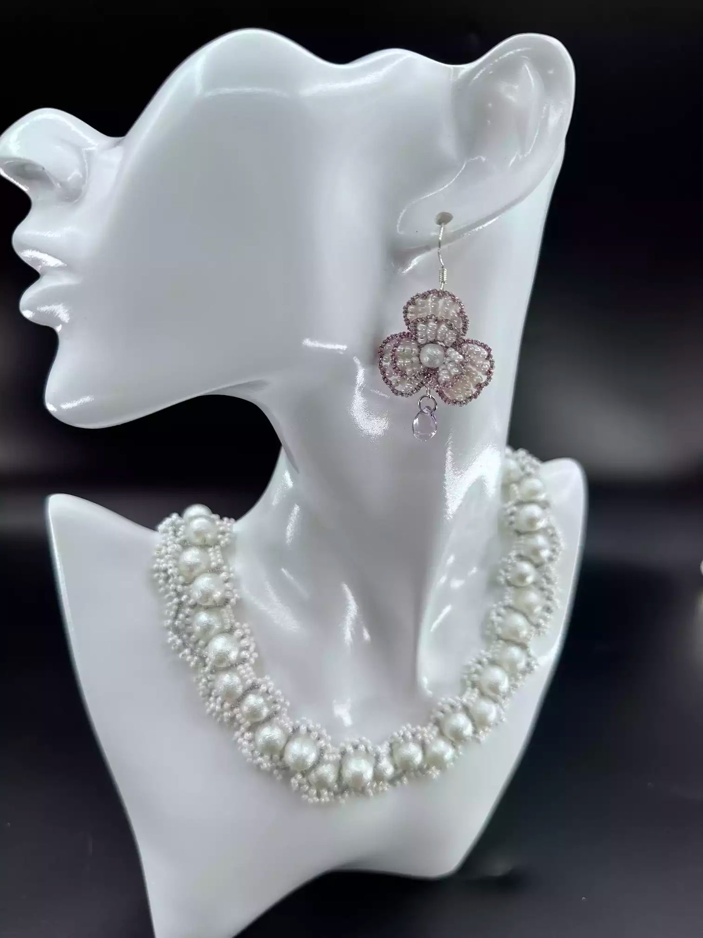 Handcrafted Violet Petal Cascade Camellia beaded dangle earrings with white glass beads, purple woven edges, and a sparkling crystal drop. A single in the picture.