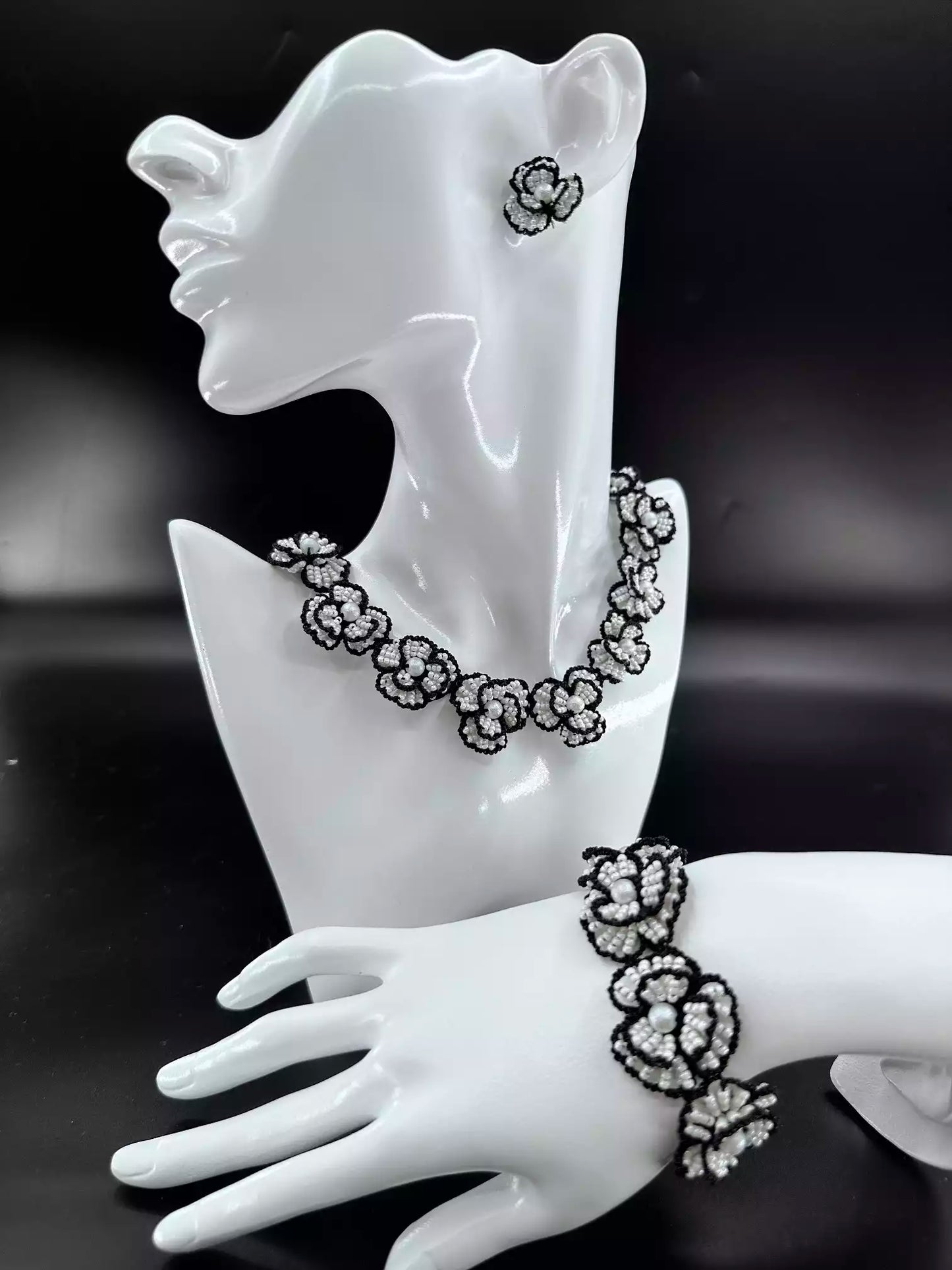 Handcrafted Classic White Camellia beaded stud earrings with white glass beads and black woven edges. A single in the picture.