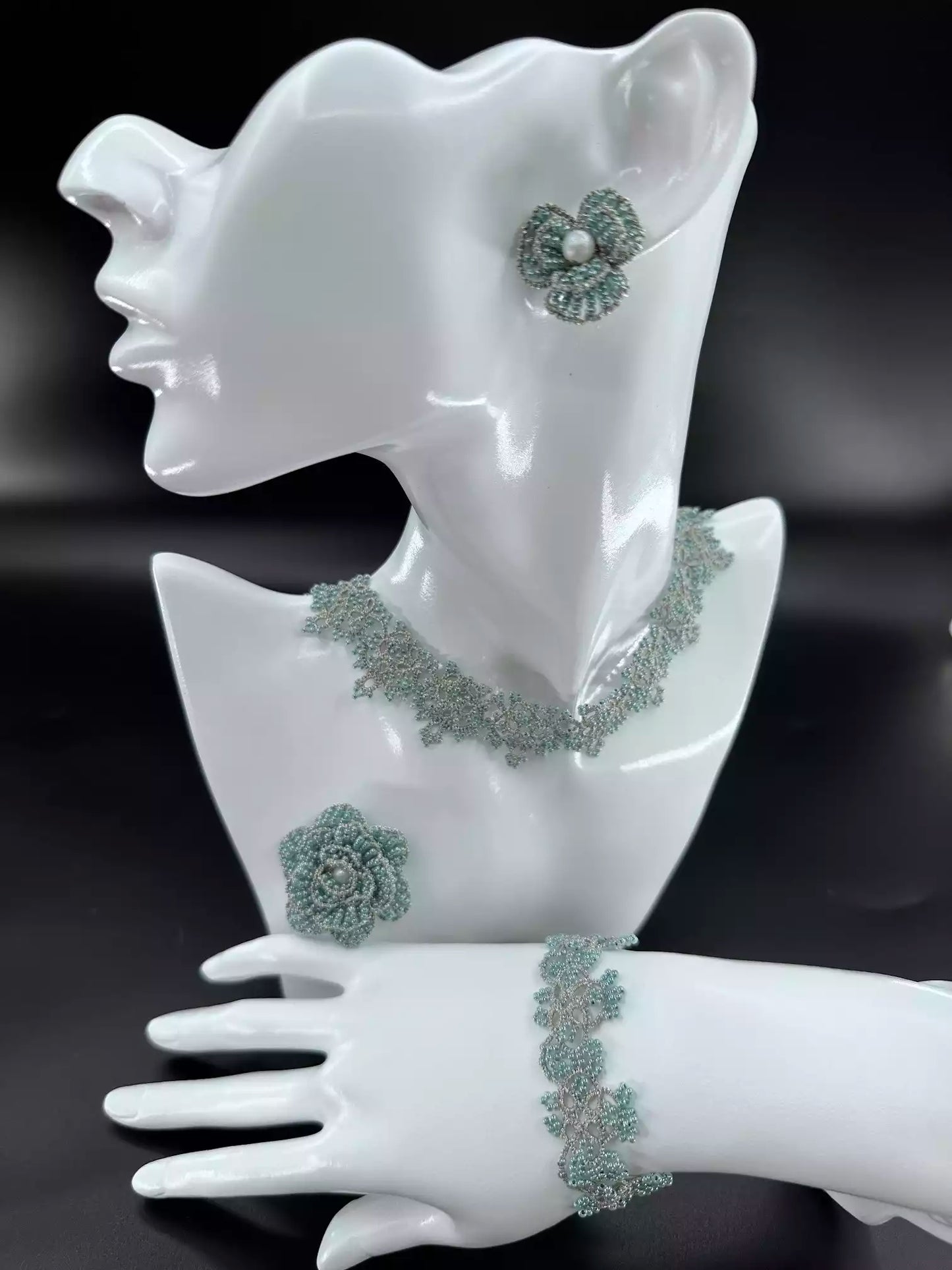 Handcrafted Emerald & Gold Camellia beaded stud earrings with green glass beads and golden woven edges. A single in the picture.