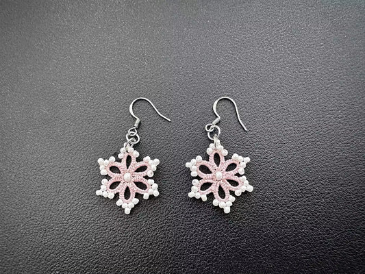 Handcrafted pink and white tatting lace snowflake earrings, hexagonal shape with delicate pink thread and small white glass beads on edge, larger white bead in center, elegant and pure design