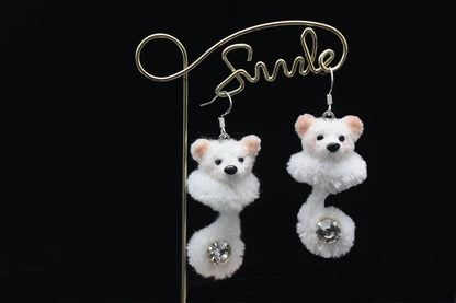 Handmade white wool twisted stick puppy earrings with light brown ears, subtle blush, and a sparkling gem on the curled tail, front view.
