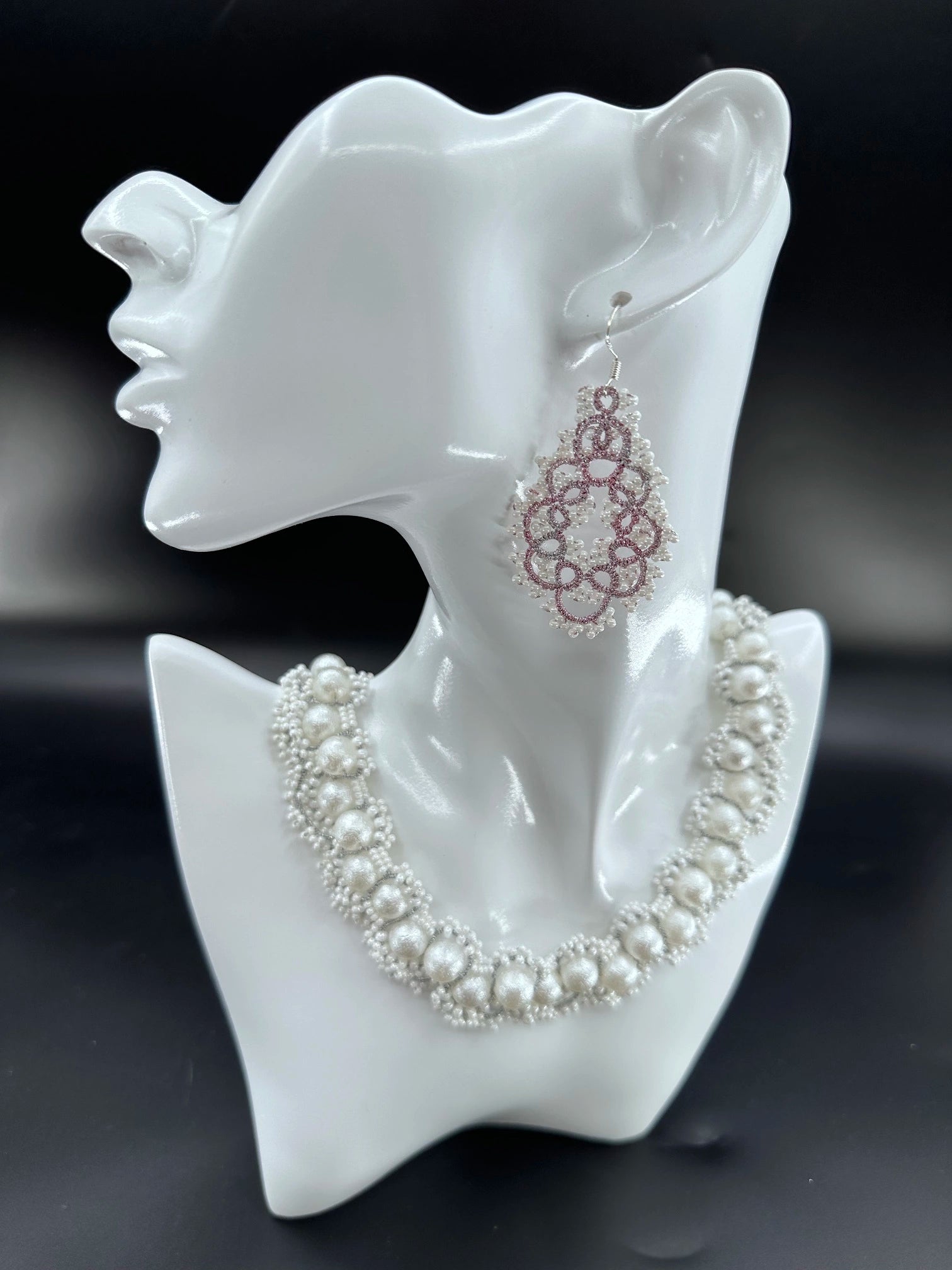 Close-up of a handcrafted Gourdlet dangle earring featuring delicate purple threadwork and clustered white glass beads, perfect for elegant styles