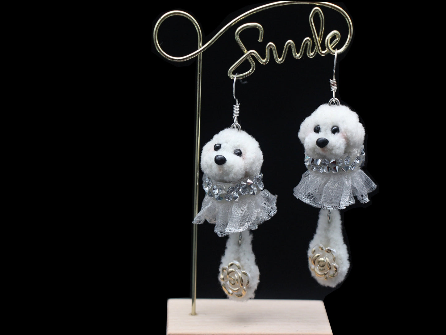 Handmade white wool twisted stick puppy earrings with silver lace skirts, front view.