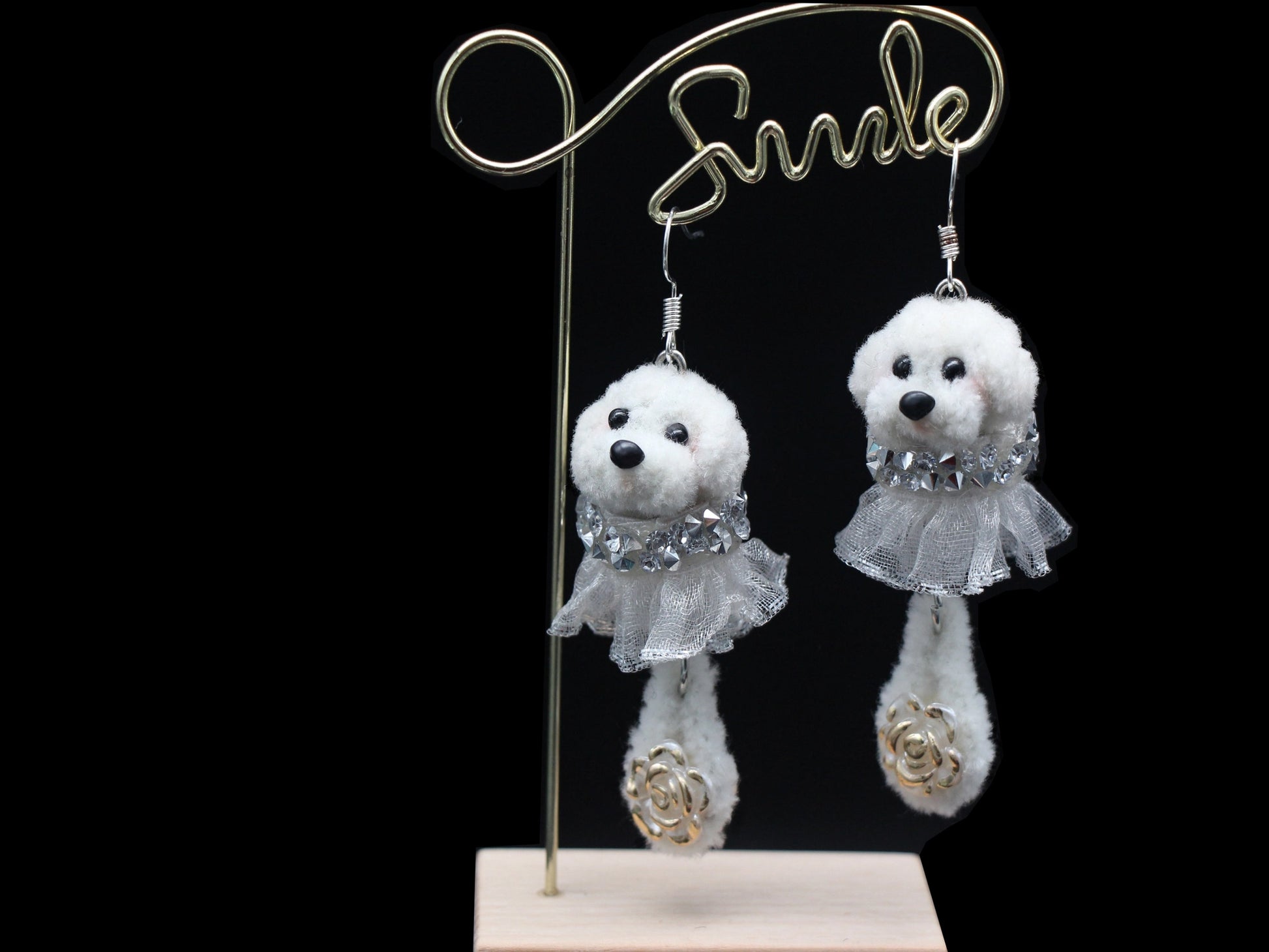 Handmade white wool twisted stick puppy earrings with silver lace skirts, front view.