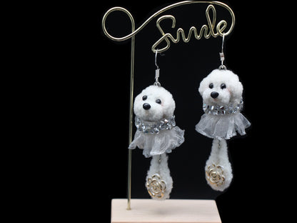 Handmade white wool twisted stick puppy earrings with silver lace skirts, front view.