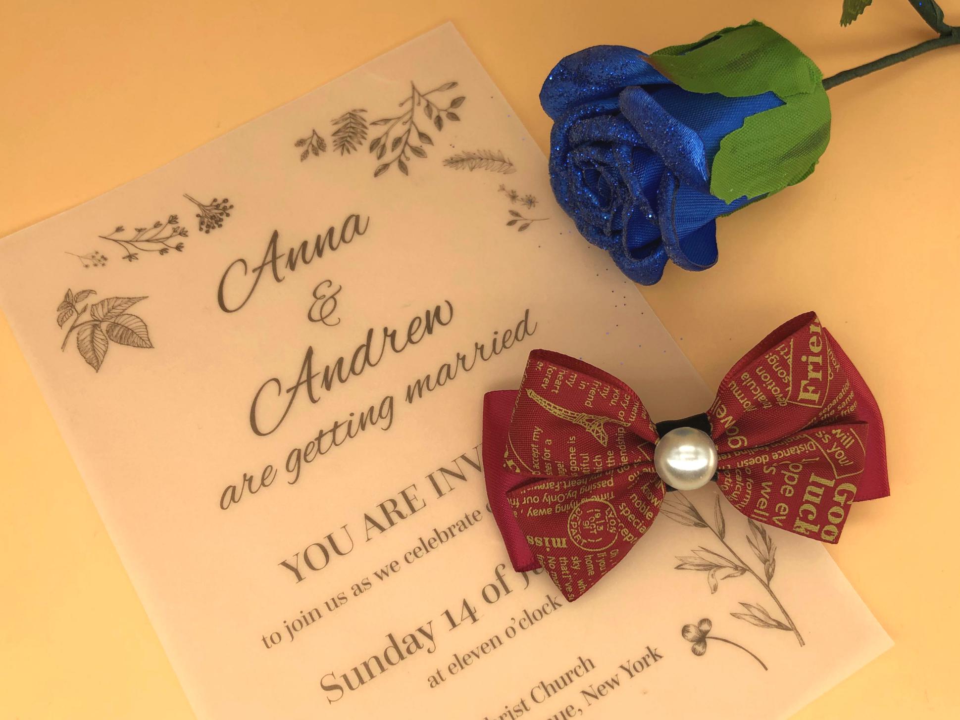 Handmade layered red hair bow with patterned & solid ribbons, central faux pearl on a clip.