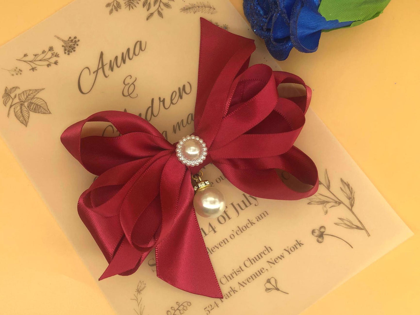 Handmade layered red satin bow (thin & wide ribbons), wrapped center, two beads.