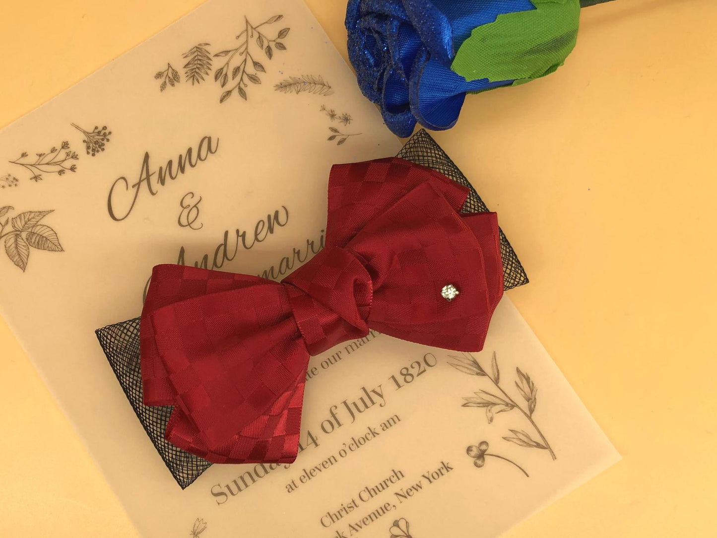 Red plaid ribbon bow with black chiffon underlay, sparkling rhinestone accent (lower right).