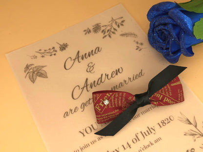 Handmade red ribbon hair clip with text pattern, tied with black ribbon, and with a small sparkling rhinestone accent.